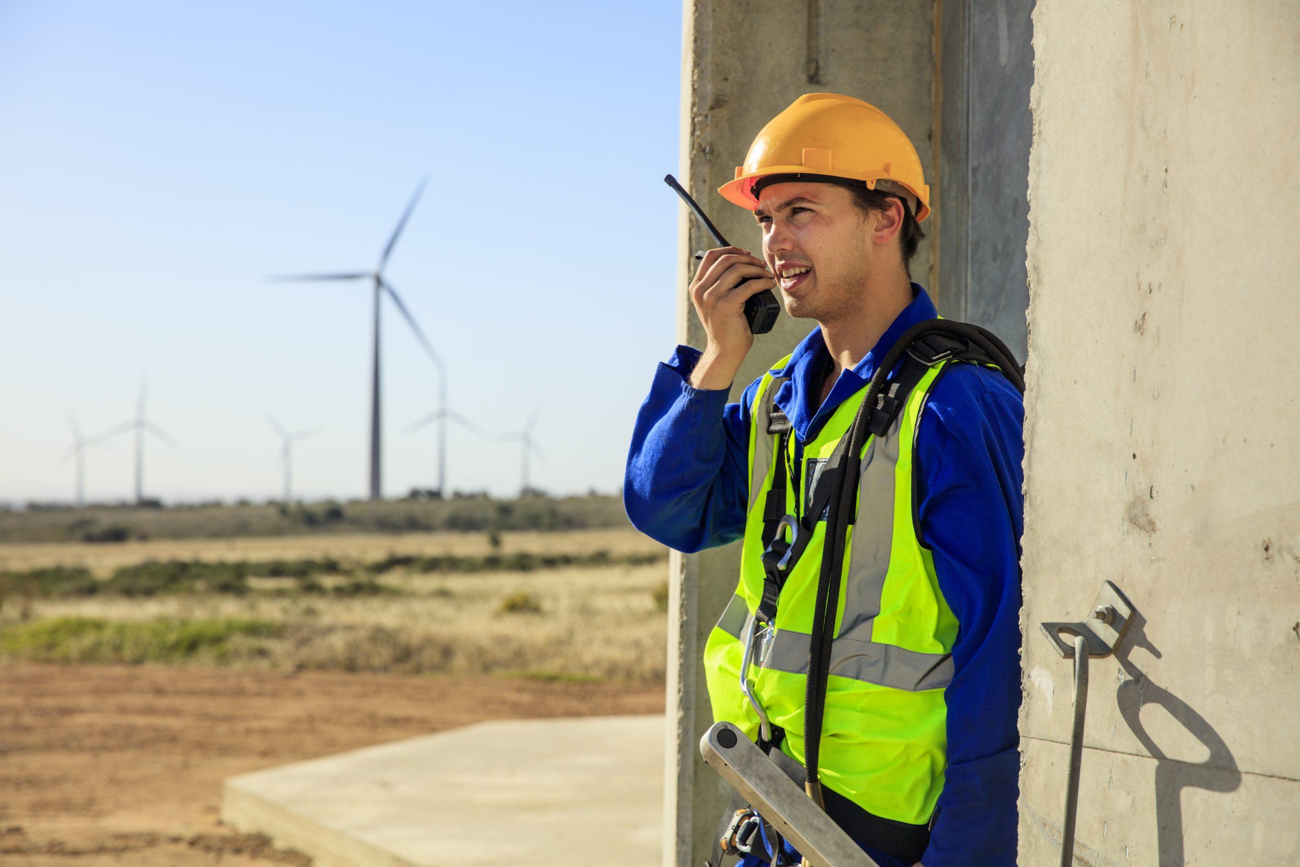 Technician using walkie-talkie at wind turbine